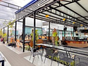 a restaurant with tables and chairs on a roof at Ohana Phnom Penh Palace Hotel in Phnom Penh