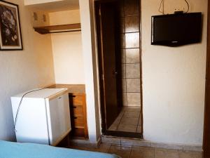 a small kitchen with a refrigerator and a television at Hotel center Ribeirão in Ribeirão Preto
