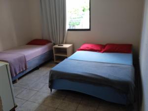 a bedroom with two beds and a window at Hotel center Ribeirão in Ribeirão Preto