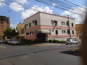 a building on a street with cars parked on the street at Hotel center Ribeirão in Ribeirão Preto