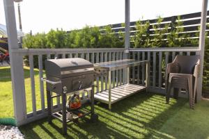 a grill on a balcony with a table and a chair at VLD House A Frame in Vadu