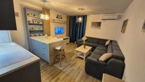 a living room with a couch and a kitchen at APARTMANI PAVLOVIC in Zelenika