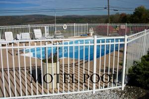 uma cerca branca ao lado de uma piscina em Longhouse Lodge Motel em Watkins Glen