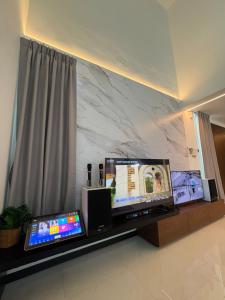 a living room with a tv and a marble wall at Chin Villa in Simpang Ampat +49 photos