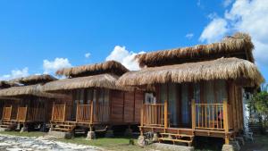 a group of huts with thatched roofs at Morgans Bungalows in Maluk