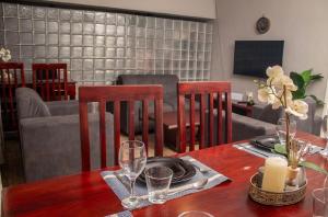 a dining table with two chairs and a table with glasses at MbaliBliss in Bulawayo