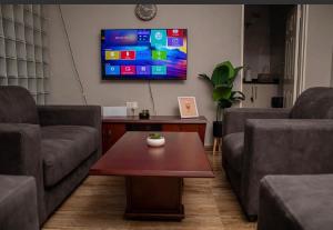 a living room with two couches and a tv at MbaliBliss in Bulawayo