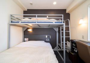 a bedroom with two bunk beds and a desk at Super Hotel Asahikawa in Asahikawa
