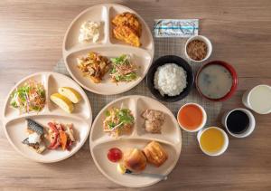 a table with four plates of food on it at Super Hotel Minami Hikone Ekimae in Hikone
