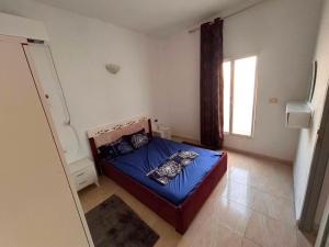 a bedroom with a blue bed with pillows on it at djerba palm house in Mezraya