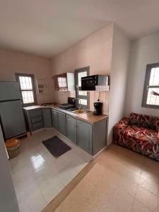 a small kitchen with a couch in a room at djerba palm house in Mezraya