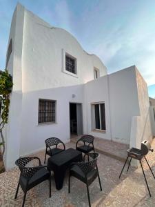 a patio with chairs and a table in front of a building at djerba palm house in Mezraya