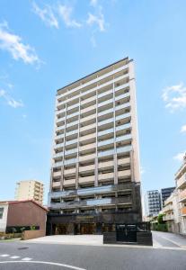 a tall white building with a street in front of it at Grand Residence Hotel Hakata Premier in Fukuoka +7 photos