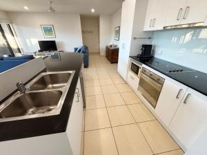 a kitchen with a sink and a stove at Watermark Apartment 2 - Bring your own linen. in South West Rocks