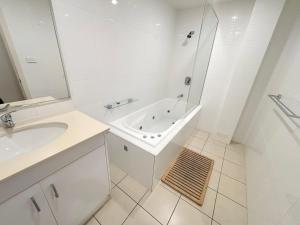a white bathroom with a tub and a sink at Watermark Apartment 2 - Bring your own linen. in South West Rocks +11 photos