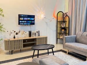 a living room with a couch and a tv at 4B 3R Cozy Spacious Near Dewan Millenium Fully Aircond in Kepala Batas