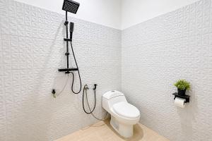 a bathroom with a toilet and a shower at RedDoorz at Residence Bintaro in Mencil +8 photos