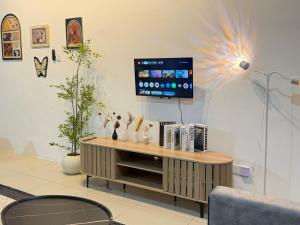 a living room with a tv on the wall at 4B 3R Cozy Spacious Near Dewan Millenium Fully Aircond in Kepala Batas