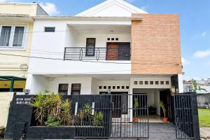 a house with a black gate in front of it at RedDoorz at Residence Bintaro in Mencil