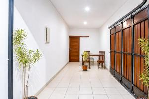 a hallway with a door and a table and chairs at RedDoorz at Residence Bintaro in Mencil