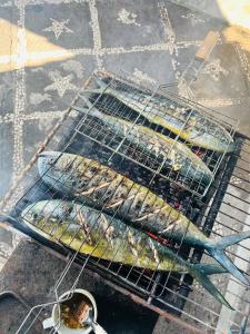 two racks of fish cooking on a grill at Tradisi Villas in Amed