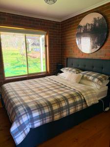 a bed in a bedroom with a brick wall at Noojee Getaway in Noojee