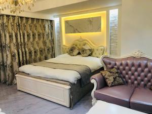 ein Schlafzimmer mit einem Bett und einer Couch in der Unterkunft ロコズリゾートハワイandオアフ in Honjo