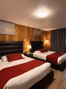 a hotel room with two beds with red and white sheets at Mountain View Hope Motel in Hope