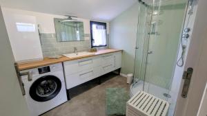 a bathroom with a washing machine and a shower at Appartement in Lorp Sentaraille +9 photos