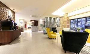 a lobby of a store with yellow and black chairs at Brooks Hotel Tongyeong in Tongyeong