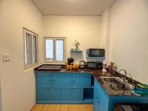 a kitchen with blue cabinets and a counter top at Studio By The Garden in Jawlakhel