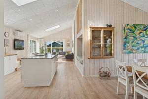 a kitchen and living room with a table and chairs at Spacious Holiday Home On Bogø in Bogø By