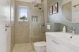 a bathroom with a shower and a toilet and a sink at Spacious Holiday Home On Bogø in Bogø By +32 photos
