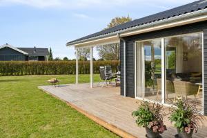 a house with a wooden deck in a yard at Spacious Holiday Home On Bogø in Bogø By