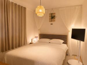a bedroom with a white bed and a television at Stay U in Suwon