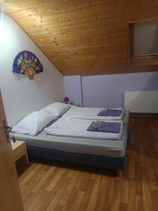 a bed in a room with a wooden ceiling at Čarodějnický Dvůr in Biskoupky +16 photos