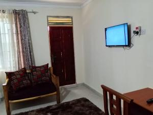 ein Wohnzimmer mit einem Sessel und einem Fernseher an der Wand in der Unterkunft Luanda Road View Hotel in Luanda