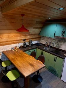 a kitchen with a wooden table and green cabinets at paşa barbun in Bartın