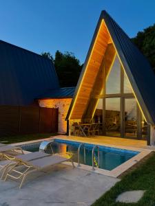 a house with a triangular roof and a swimming pool at paşa barbun in Bartın