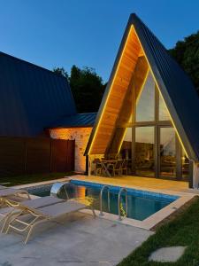 a house with a triangular roof with a swimming pool at paşa barbun in Bartın