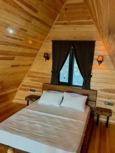 a bedroom with a bed in a wooden cabin at paşa barbun in Bartın