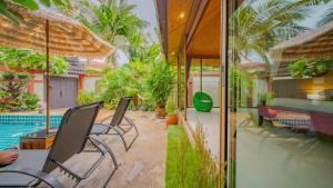 a house with a swimming pool and a patio with chairs at Pattaya Bungalow II, Totally Private Pool in Pattaya South