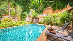 a swimming pool in a garden with trees at Pattaya Bungalow II, Totally Private Pool in Pattaya South