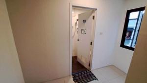 a hallway with a door to a room with a window at แกร็บสลีปโฮสเทล แอร์พอร์ตดอนเมือง in Ban Ko