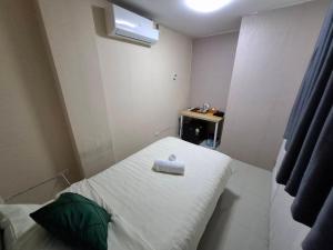 a small room with a bed and a small table at แกร็บสลีปโฮสเทล แอร์พอร์ตดอนเมือง in Ban Ko