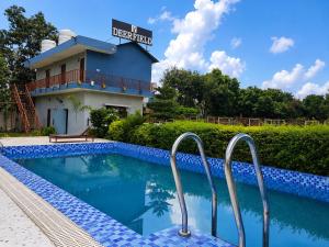 a swimming pool in front of a building at The Deerfield Cottages in Rāmnagar