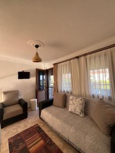 a living room with a couch and a chair at Belfin Pansiyon Ovabükü in Döşeme