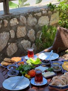 a table with plates of food on top at Belfin Pansiyon Ovabükü in Döşeme +17 photos