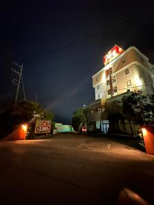 ein weißes Gebäude mit einer Leuchtreklame darauf in der Unterkunft ロコズリゾートハワイandオアフ in Honjo
