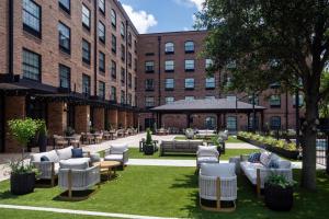 a courtyard with couches and chairs in front of a building at The Clara Hotel Plano, Tapestry Collection by Hilton in Plano